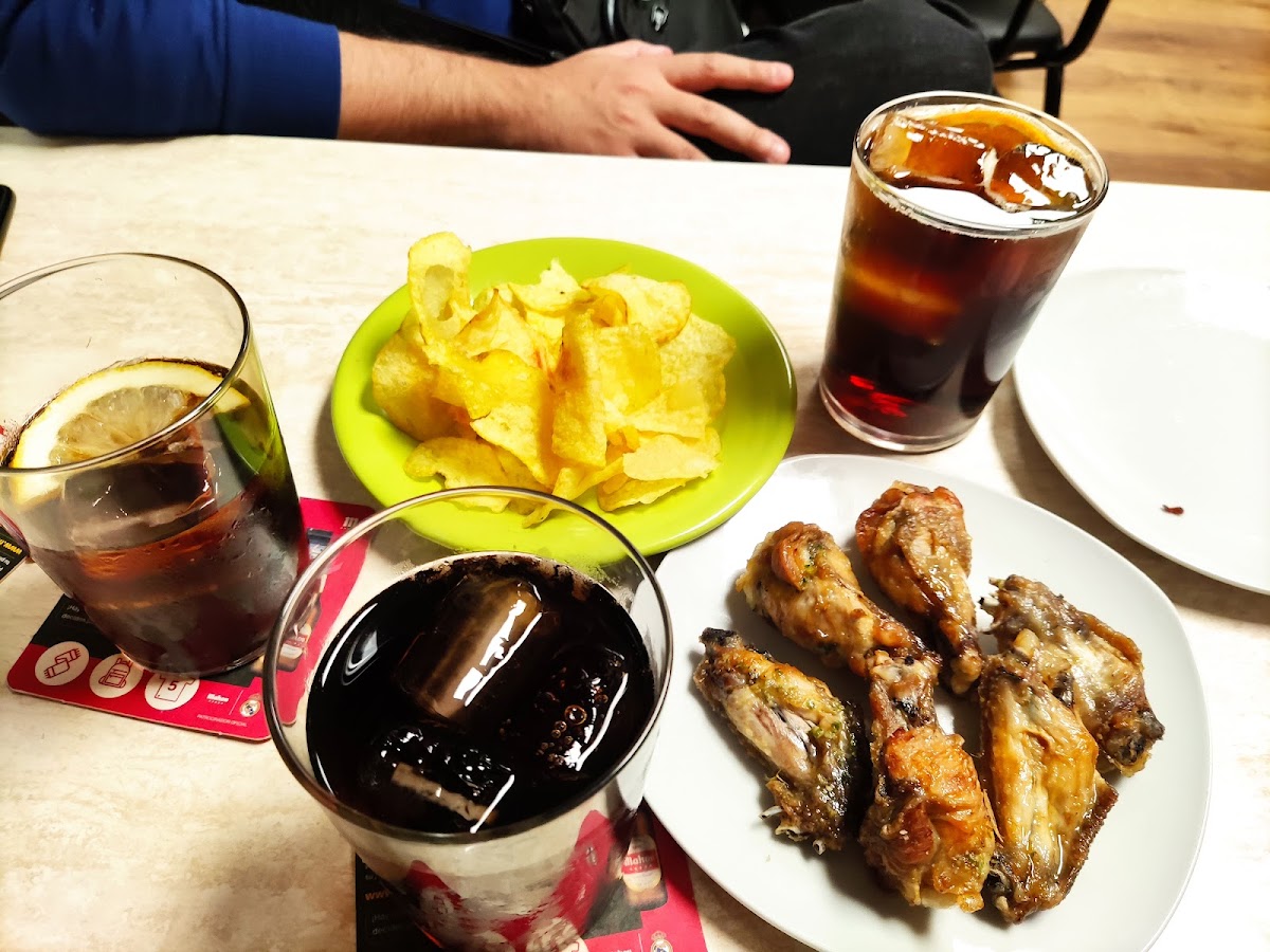 Plato de alitas de pollo doradas con patatas fritas